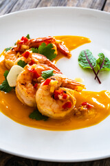 Shrimps salad with ginger and chili in mango sauce on wooden table
