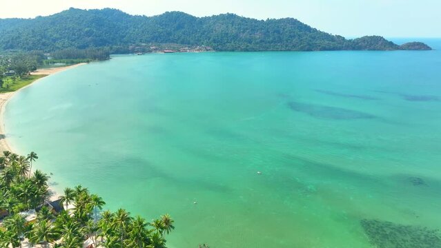 Capture the essence of tropical bliss from the sky, a lush, green coastline caressed by the sparkling blue sea - sheer beauty. Tourist destinations concept. Nature stock footage. Ko Chang, Thailand. 
