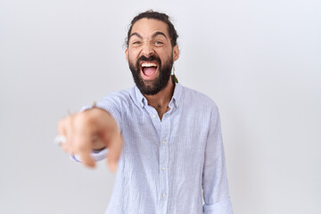 Hispanic man with beard wearing casual shirt pointing displeased and frustrated to the camera,...