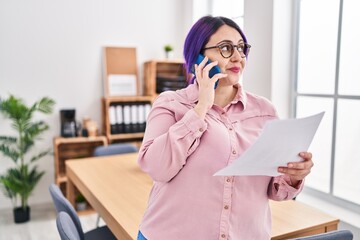 Young beautiful plus size woman business worker talking on smartphone reading document at office