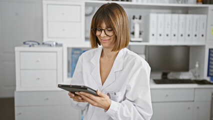 Smiling young latina, a beautiful lab scientist at work. harnessing the power of tech touchpad...