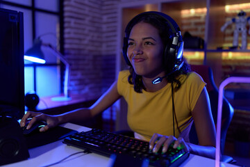 Young african american woman streamer playing video game using computer at gaming room