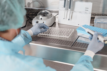 Back view of scientist is using micropipette for biochemical test analysis in medical laboratory