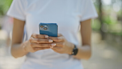 African american woman using smartphone walking at park