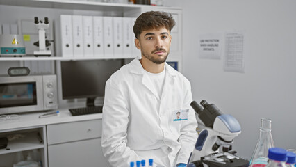 Young arab man scientist using microscope at laboratory