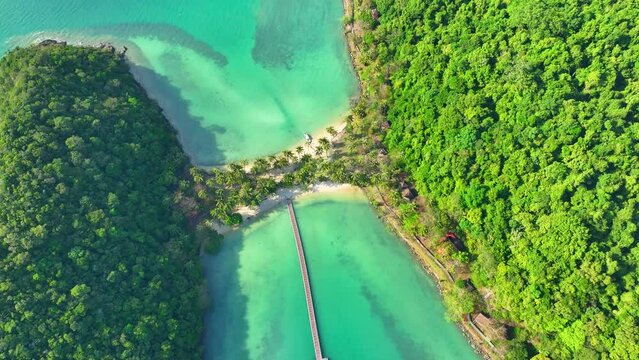 Drone captures the beauty of a tropical island. Turquoise sea, sandy beach, coconut palms, and vibrant green coastline. Nature reserves concept. Ko Ngam, Mu Ko Chang National Park, Thailand. 4K HDR.
