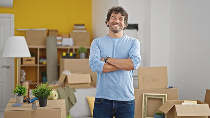 Young hispanic man smiling confident standing with arms crossed gesture at new home