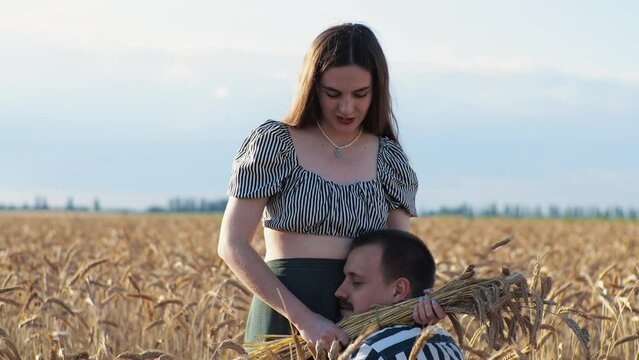 Man and woman on a date in the field. They stand, caress. Golden hour, sunset. Summer