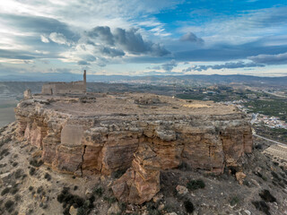 Aerial view of Castillo de Alcalá or Castillo de La Puebla, Arab castle in Murcia province Spain on top of a flat-top limestone mountain. Large rectangular tower, angled entrance, deep well and cister