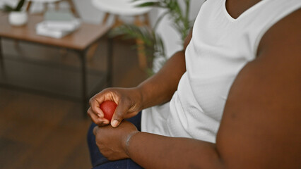 Stressed african american woman pressing anti stress ball in waiting room, nervously awaiting...