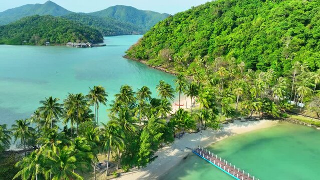Aerial view of a pristine tropical island, where azure seas kiss golden sands, framed by a vibrant green coastline. Natural wonders concept. Cinematic footage. Ko Ngam island, Thailand. 4K HDR.
