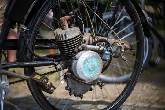 WERDER (HAVEL), GERMANY - MAY 20, 2023: Single-cylinder engine on the wheel of an antique bicycle. Close-up. Swirl bokeh. Art lens. Oldtimer - Festival Werder Classics 2023
