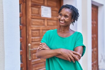 Fototapeta premium Middle age african american woman standing with arms crossed gesture at street