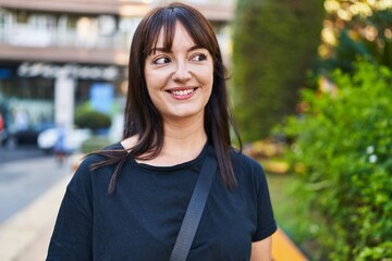 Fototapeta premium Young beautiful hispanic woman smiling confident looking to the side at park