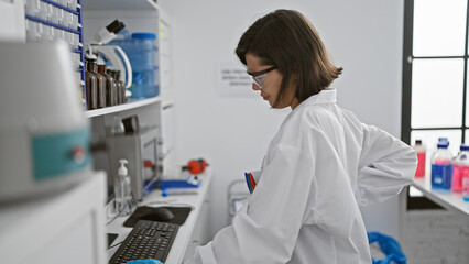 Overworked young hispanic scientist at her wit's end, beautiful woman suffers backache from hours...