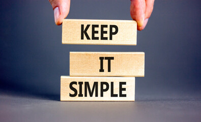 Keep it simple symbol. Concept word Keep it simple on beautiful wooden block. Businessman hand....