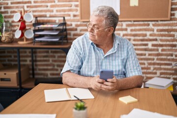 Middle age grey-haired man business worker using smartphone working at office