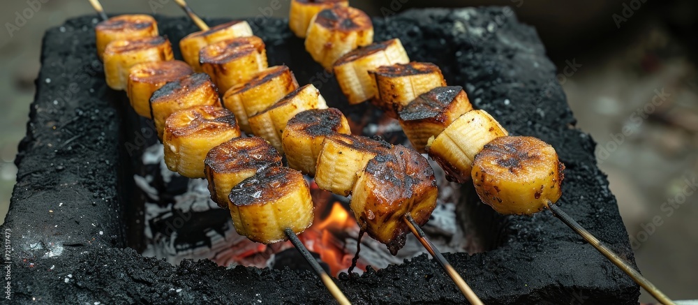 Poster delicious banan skewers toasting over charcoal on stove: a sizzling banan skewers toasting experienc