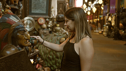 A young woman explores the traditional market in dubai, touching an artisanal sculpture among other cultural wares.