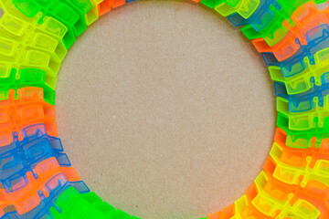 Colorful segments of construction race track toy arranged in loops on a cardboard background