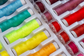 Multicolored threads and plastic bobbins for sewing machines