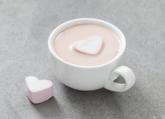 Festive drink. Chocolate cappuccino with marshmallows in the shape of a heart. In a cup. Light grey background. Close up. Valentine's Day
