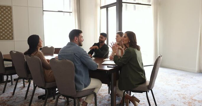 Five millennial multi-racial employees, professional marketing department, diverse workgroup met in conference room lead discussion, share opinion, talk to mates. Business, communication, strategizing