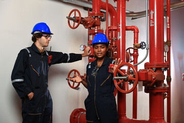 Male and Female engineer working in fire extinguishing room , extinguishing piping system