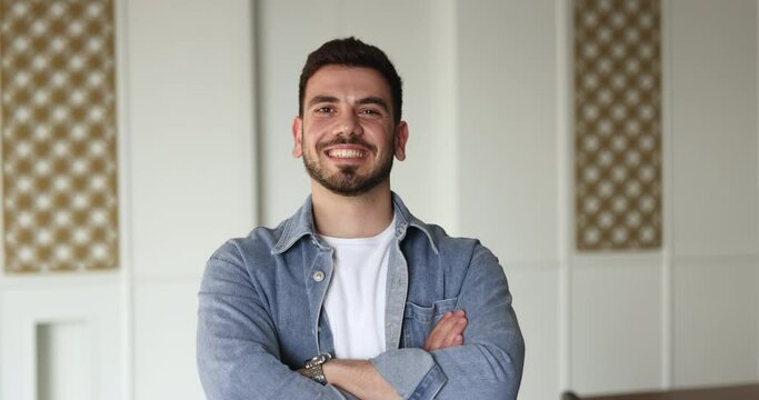 Head shot of young smiling Syrian businessman in casual clothes standing in office look at camera. Motivation, leadership, career growth, successful company member or startup project leader portrait