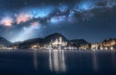 Milky Way over the church on the snowy island on the Bled Lake, Slovenia at winter starry night....