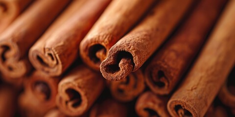 A close-up view of a pile of cinnamon sticks. Perfect for adding warmth and flavor to your culinary creations or for creating a cozy atmosphere in your home decor