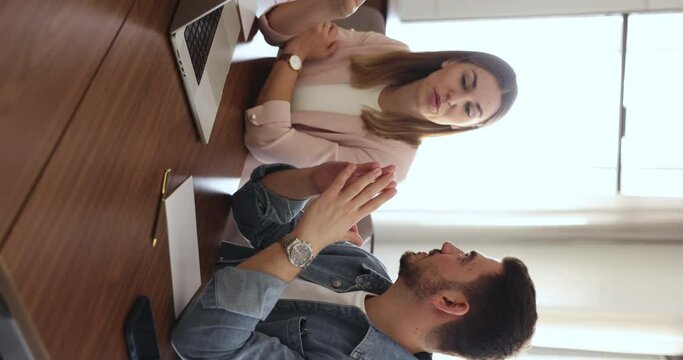 Tteammates consider joint task, work sit at desk with laptop. Corporate employees planning marketing strategy, search solution, engaged in teamwork. Meeting of manager and client in office