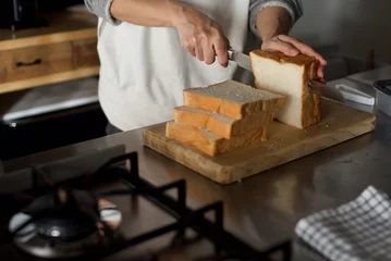 Fotobehang 一斤で買った食パンをパン切り包丁で切っているところ © Takahiro