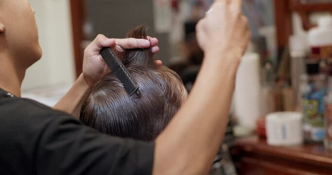 Soft focus Hairdresser cuts hair, combs it. Stylish boy sitting in a hairdresser. Barber man cuts hair of cute little boy child. Attractive man getting his hair cut in a modern barbershop. 4K