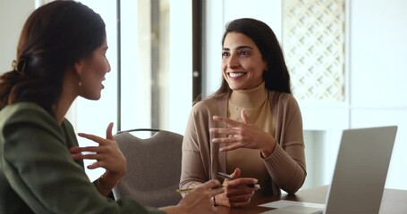 Two attractive women teammates lead discussion met in office. Sales manager selling company services at formal meeting with client in office. Negotiations, joint project, share solution and teamwork