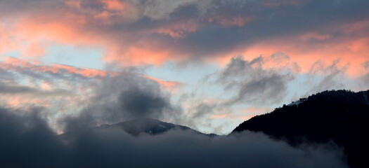 Sunset after a rainy day with grey and red clouds over the Val d'Ultimo near Merano in South Tyrol	 - obrazy, fototapety, plakaty