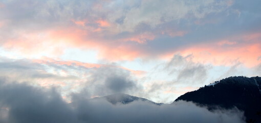 Sunset after a rainy day with grey and red clouds over the Val d'Ultimo near Merano in South Tyrol - obrazy, fototapety, plakaty