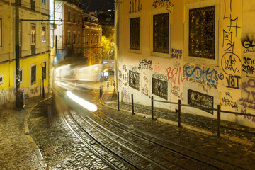 Long exposure of street view of historical funicular Elevador da Gloria driving uphill during a...