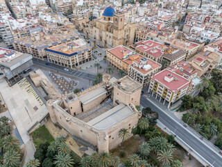 Aerial view of Elche (Elx) historic center, Altamira medieval castle national monument, palm trees dramatic sunset sky