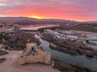 Aerial colorful sky sunset panoramic view of Flix new castle above the Ebro river in Spain with triangular shape circular gun platforms