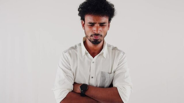 Portrait of a thoughtful crying man with crossed arms on a white background