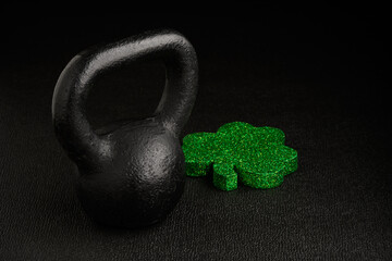 Holiday fitness and Happy St. Patick’s Day, green glitter shamrock shape with a black iron...