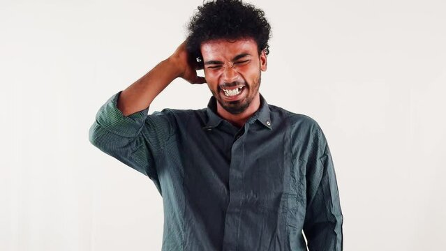 laughing young man scratching his head isolated on a white background