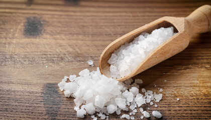 Obraz na płótnie Canvas salt crystals with wooden scoop on wooden table