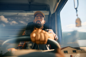 Close up of African American driver driving truck. - obrazy, fototapety, plakaty