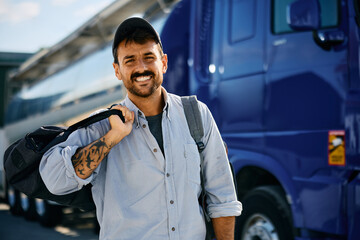 Happy truck driver on parking lot looking at camera. - obrazy, fototapety, plakaty