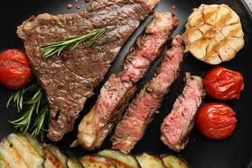 Delicious grilled beef steak with vegetables and spices on plate, top view