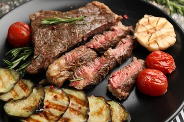 Delicious grilled beef steak with vegetables and spices on plate, closeup