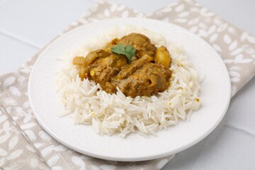 Delicious chicken curry with rice on white tiled table, closeup