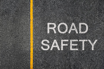 Road Safety written on the asphalt. Traffic lane with yellow separation line. Highway graphic texture concept